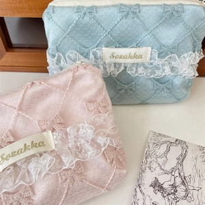 Detail of blue and pink quilted lace cosmetic bags with elegant bow and embroidery
