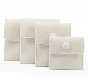 Detailed set of four beige velvet jewelry pouches with snap buttons in graduated sizes