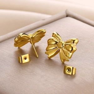 Macro view of 18K gold plated stainless steel bow earrings with high-polished texture