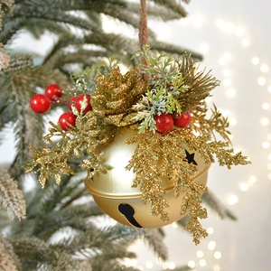 Champagne gold Christmas bell with red berries and pine needles on a festive tree