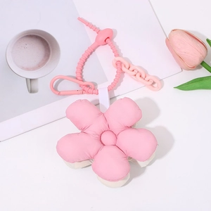 Close-up of a cute pink five-petal flower keychain charm with matching strap and clasp