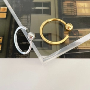 Close-up of minimalist 925 sterling silver ball rings in gold and silver finishes