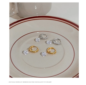 Detail of silver drop earrings with water drop zirconia pendants on a ceramic tray