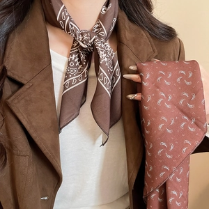 Detail of vintage paisley silk scarf necklace in brown and brick red tones with silky texture