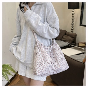 Floral canvas tote bag with drawstring closure showing side view on female model