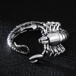 Detailed close-up of a silver stainless steel scorpion bracelet on a dark textured background