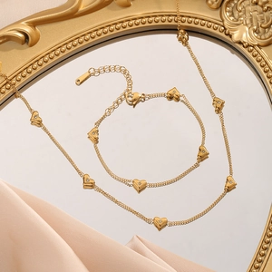 Golden heart jewelry set with necklace and bracelet featuring zircon stone details