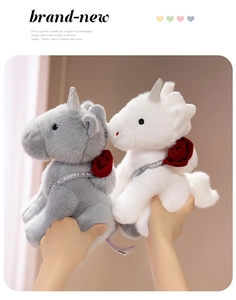 Detailed view of plush unicorn toys featuring red rose neck decor and silver horns