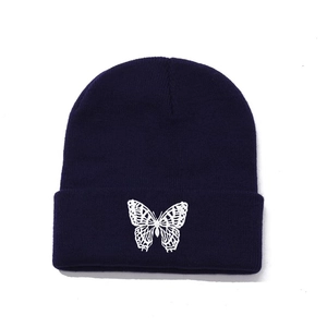 Navy blue knit beanie with white butterfly embroidery and vertical ribbed texture