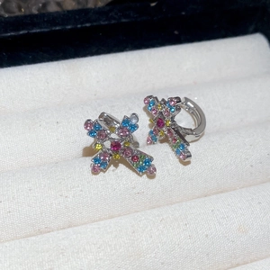 Detail of cross hoop earrings with multicolored pavé zircon stones in a silver setting