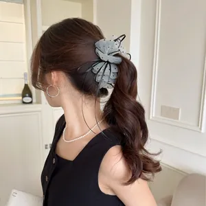 Korean style white mesh bow hair clip with black polka dots on a ponytail hairstyle