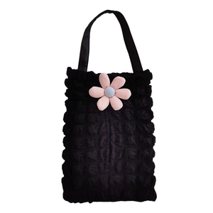 Detail of black waffle-textured car tissue holder with pink floral accent and strap
