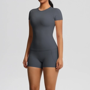 Front view of grey short sleeve yoga top and high waist leggings on a female model