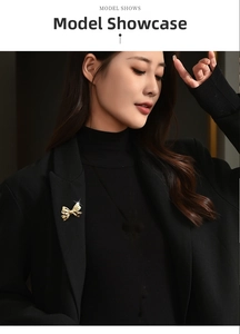 Close-up of golden bow brooch pinned on a black blazer lapel with elegant polished finish