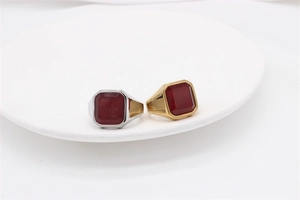 Detailed view of silver and gold square signet rings with ruby-like stone for men