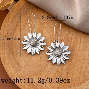 Detail shot of vintage silver sunflower earrings on wood with size and weight info
