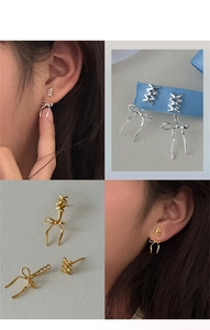 Dettagli di orecchini a fiocco in argento e borchie geometriche su modella e primo piano
