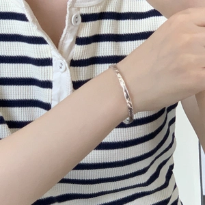 Minimalist S925 sterling silver bangle with unique hammered gold foil texture on model