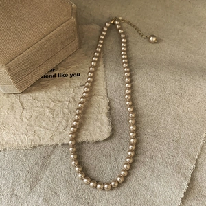 Detailed macro view of French vintage pearl necklace with champagne gold adjustable chain