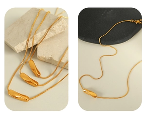 Macro detail of golden snake chain necklace with a minimalist twisted metal pendant