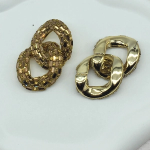 Detail view of interlocking chain earrings with gold plating and sparkling crystals