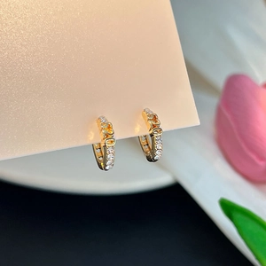 Vue macro de boucles d'oreilles 520 dorées avec pavé de zircons sur carte cadeau