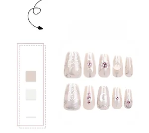 Detail of handmade press-on nails featuring silver celestial sun and moon patterns