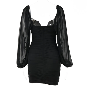 Close-up of black mesh long sleeve dress showing backless design and ruched detail texture