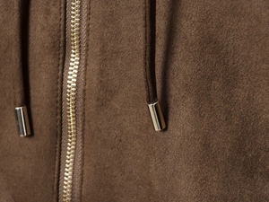 Close-up of metal zipper and drawstring on dark brown suede bomber jacket detail