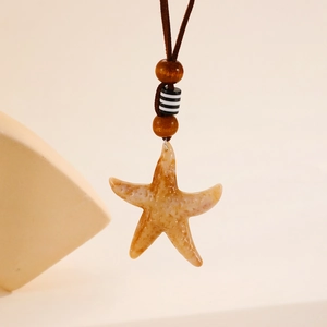 Détail du pendentif étoile de mer avec textures naturelles et perles en bois