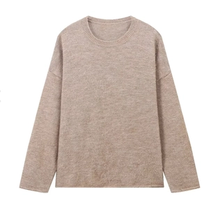Détail du pull en maille avoine montrant la texture douce et le col rond côtelé