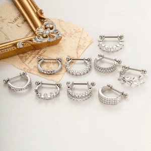 Set of 9 silver stainless steel nose rings with sparkling zircons on elegant background