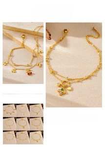 Detail of gold double-layered anklet with cherry and starfish charms for women