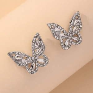 Détail macro de boucles d'oreilles papillon en argent avec pierres pavées et cristaux