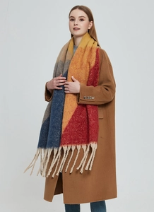 Close-up of thick tassels on a colorful plaid faux mohair scarf with vibrant grid patterns