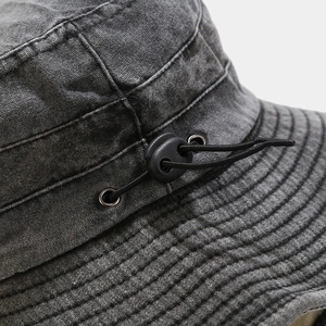 Detail of adjustable elastic drawstring and plastic cord lock on washed cotton sun hat