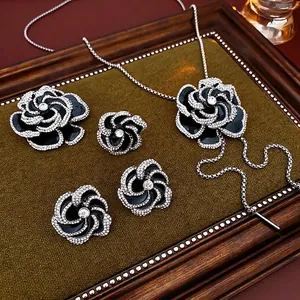 Elegant black enamel camellia flower necklace and earrings set with crystal accents