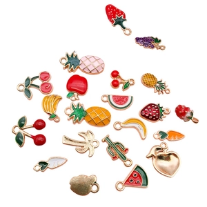 Assorted colorful enamel fruit and plant charms for DIY jewelry making on white background