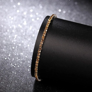 Macro shot of single row amber crystal bracelet on black stand with sparkling background