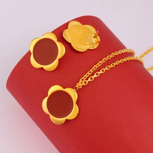 Luxurious gold stainless steel jewelry set featuring red clover necklace and earrings