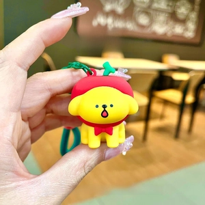 Detail view of cartoon dog keychain with red apple hat and green plastic lanyard strap