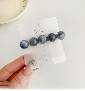 Deep blue marble heart hair clips set held in hand showing high quality resin texture