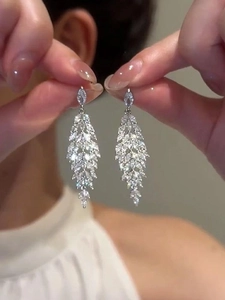 Detail of silver leaf drop earrings with sparkling zircon crystals and long tassels