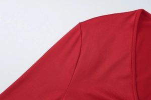 Gros plan détaillé de la robe rouge montrant les coutures et la texture du tissu tricoté