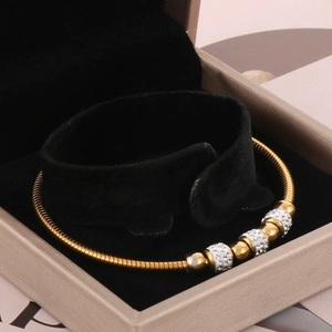 Macro detail of a 18K gold plated snake chain bracelet with sparkling rhinestones in a box