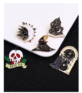 Macro view of five unique Halloween enamel pins including skull apple and magic themes