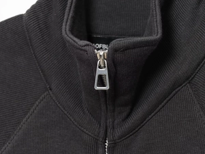 Close-up of the silver metal zipper and knit texture on the black stand-collar sweatshirt