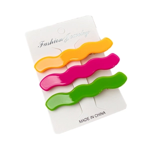 3-piece set of wavy macaron acetate hair clips in orange, pink, and green on white card