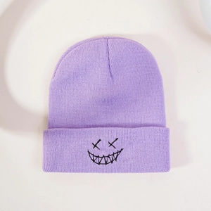 Close-up of purple ribbed knit beanie featuring black embroidered grimace face pattern