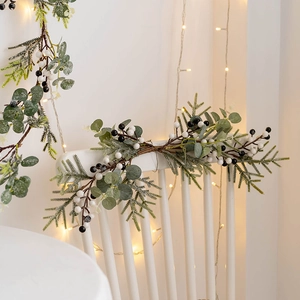 Artificial Christmas garland with eucalyptus, pine needles and berries on a chair
